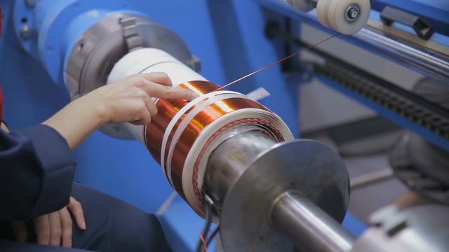 Transformer, engine production. Worker winding cooper wires on a high voltage transformer. Slider shoot. HD.
