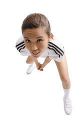 Young woman standing, looking up at camera, hands clasped