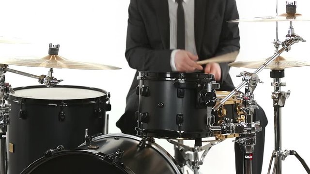 musician in tuxedo playing drums isolated on white background