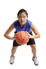 Young woman holding basketball, aiming for a hot