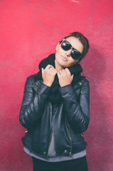 Portrait of young caucasian woman with sunglasses looking at camera and standing against of purple ...