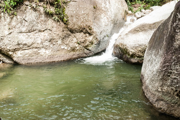 Fototapeta na wymiar Natural water pond between large stones