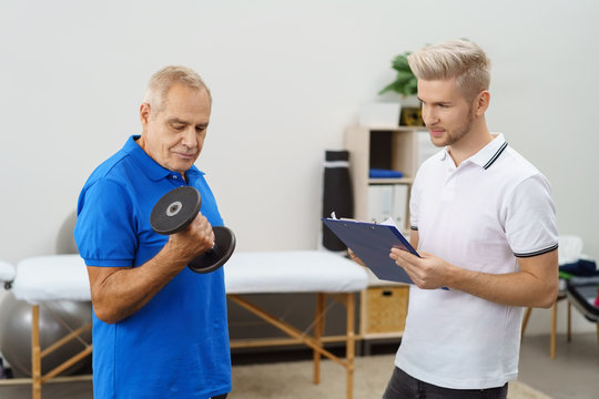 älterer mann trainiert seine arme in der physiotherapie