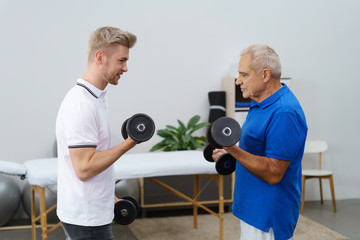 trainer und klient machen zusammen eine übung in der physiotherapie