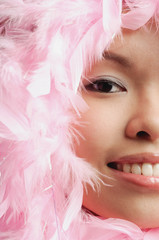 Woman with pink feathers around her face, cropped image