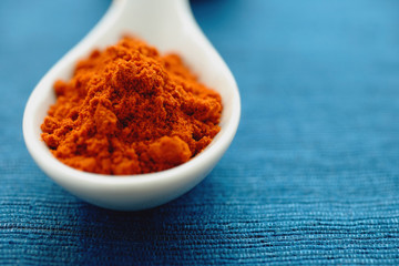 Chili powder in ceramic spoon, close- up