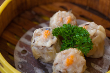 Chinese steamed dumpling or Dim sum stuffed with minced pork decorated in bamboo made steamer local style.