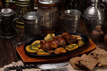 grilled ribs with potatoes on a hot skillet.