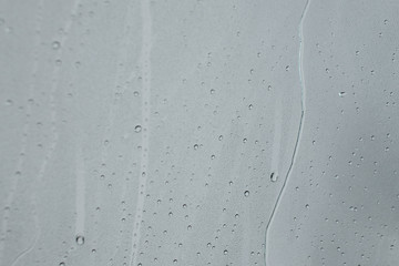 black & white water droplets and streak on glass