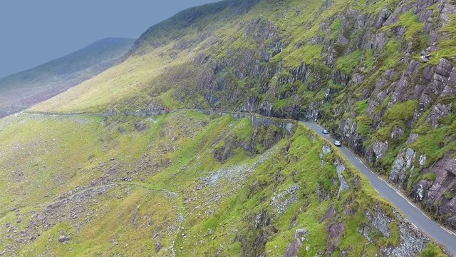 The aerial view of the mountain side in SkyRoad the big rocks and grasses in the cliff of the mountain in Ireland