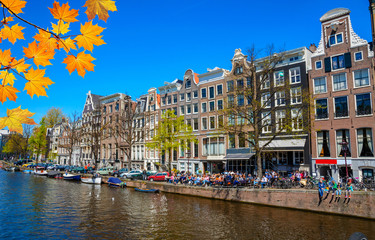 Fototapeta premium Tradycyjne stare budynki i łodzie w Amsterdamie, w Holandii