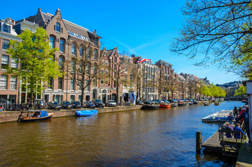 Fototapeta premium Traditional old buildings and and boats in Amsterdam, Netherlands