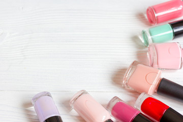 bottles of colored nail polish on wooden background