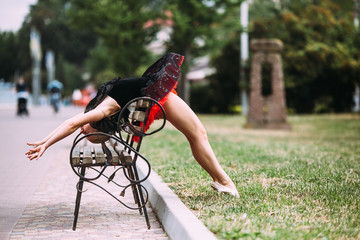 Naklejka premium Ballerina bends back through the bench