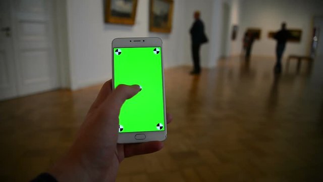 Scrolling images on a green background in art museum gallery