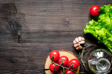 tomato, rosemary and garlic on dark wooden background top view
