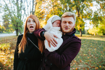 Fototapeta premium young family and newborn son in autumn park