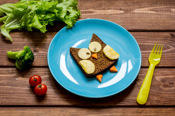 breakfast for child on blue plate at wooden background