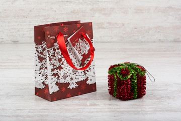 Red Christmas gift bag on a white wooden background