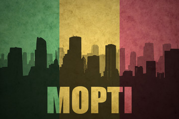 abstract silhouette of the city with text Mopti at the vintage malian flag