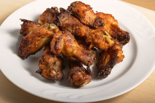 dish of spicy chicken wings on wood
