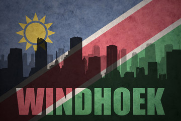 abstract silhouette of the city with text Windhoek at the vintage namibian flag