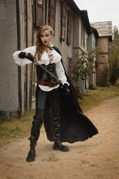 Sexy woman in pirate style holding sword