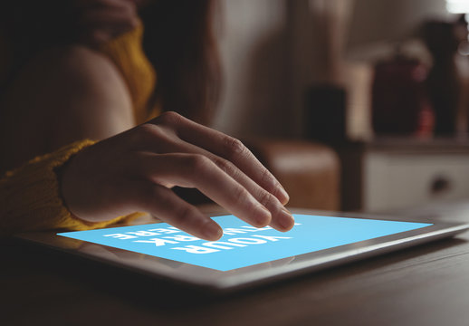 User with Tablet on Table in Bedroom Mockup