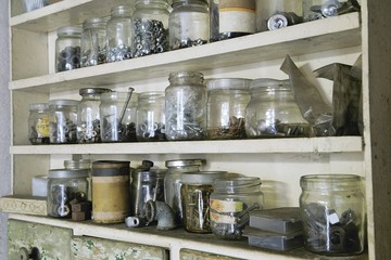 Various vintage old jars with metal bolts, nuts and screws