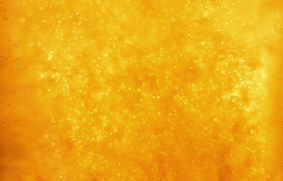 Bubbles floating in the liquid orange drink, abstract image.