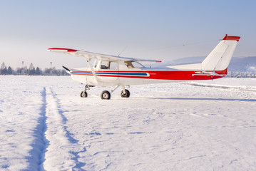 Small sports plane in winter at snow covered airport