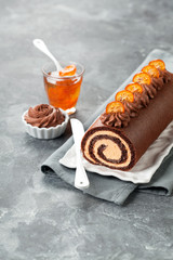 Chocolate swiss roll cake with candied kumquats, selective focus