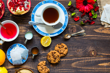 Fruit tea with lemon, milk,honey,orange, pomegranate, on a woode