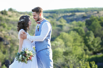 Bride and groom standing over beautiful landscape