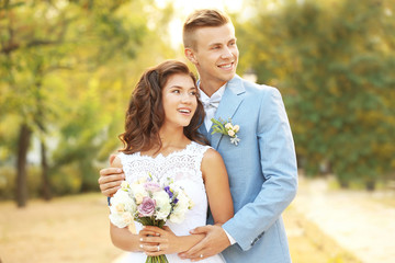 Portrait of beautiful wedding couple in park