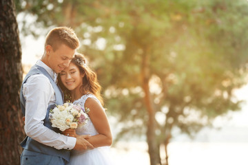 Portrait of beautiful wedding couple outdoors on blurred background
