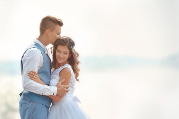Beautiful wedding couple on light blurred background, close up view