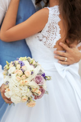 Beautiful wedding couple with bouquet of flowers, close up view