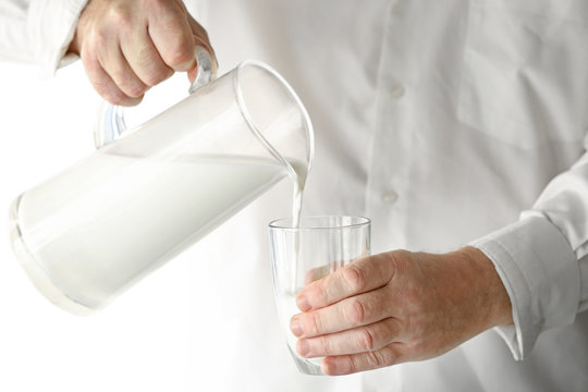 Senior man pouring milk into glass
