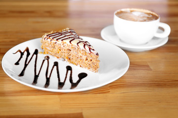 Plate with delicious dessert on wooden table at restaurant