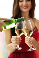 Man pouring white wine into glass, closeup