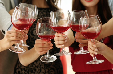 People toasting with glasses of red wine, closeup