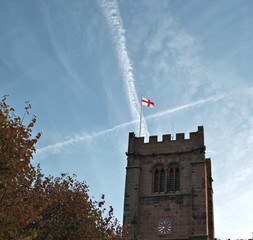 Old church tower with St George's flag on top. 