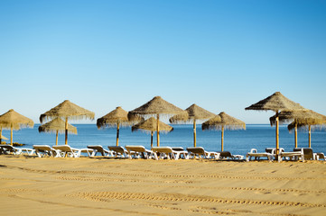 Beach umbrella chairs on the sunny blue sky beach outdoors background