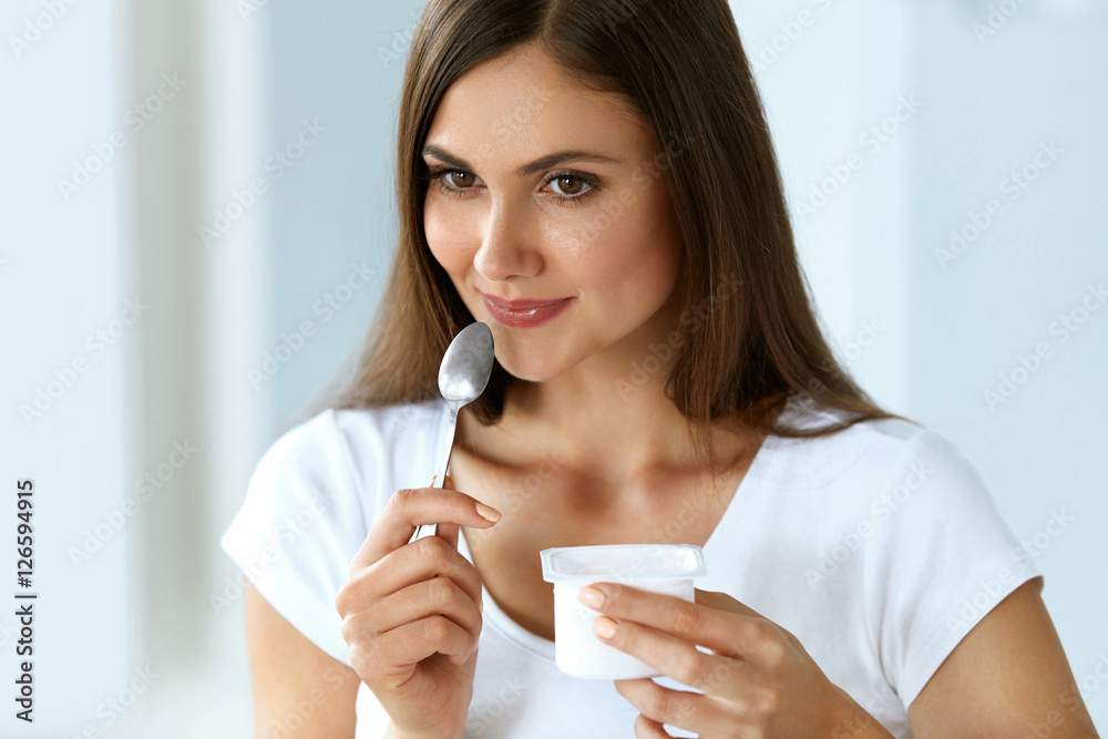 Wall mural healthy nutrition. beautiful woman eating yogurt, dairy product