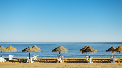 Beach umbrella chairs on the sunny blue sky beach outdoors background