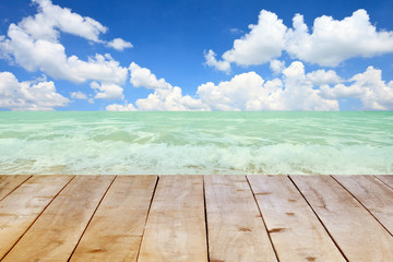 Wood table on blurred beach background.