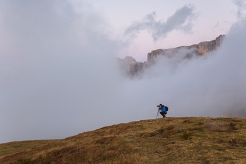Photographer taking a picture the sunset over the Dolomites Alps