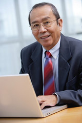 Businessman with laptop, smiling at camera
