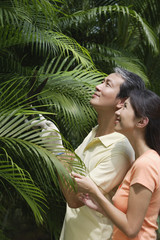 Fototapeta na wymiar Couple outdoors in garden, studying palm plant